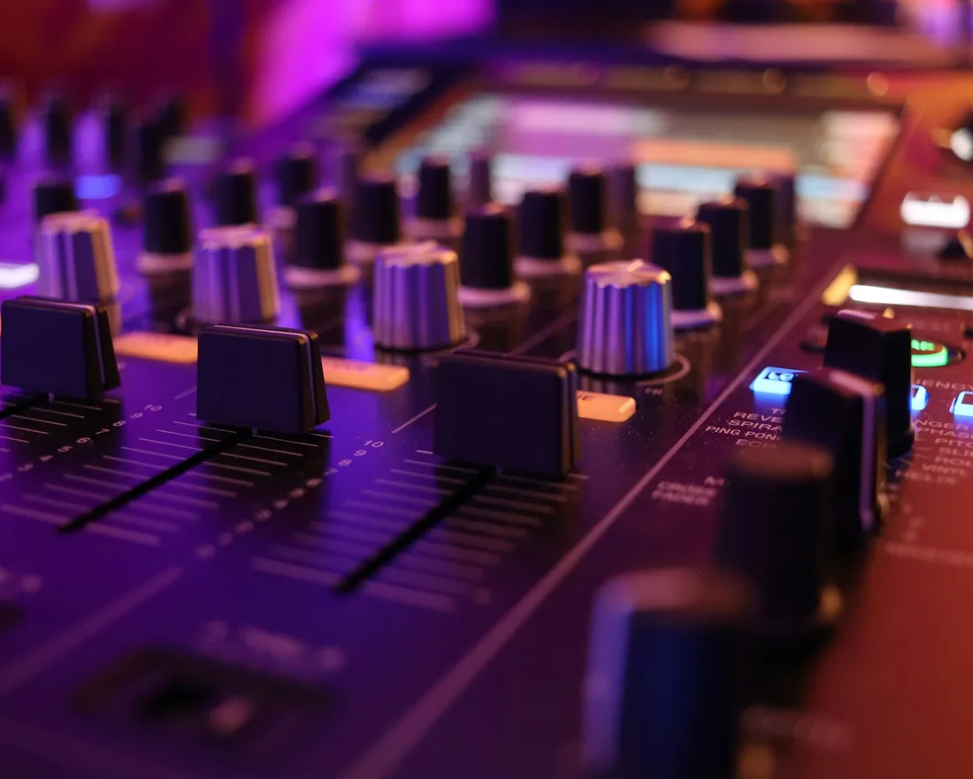 Mesa de mezclas de un estudio de grabación con faders, potenciómetros y medidores de nivel